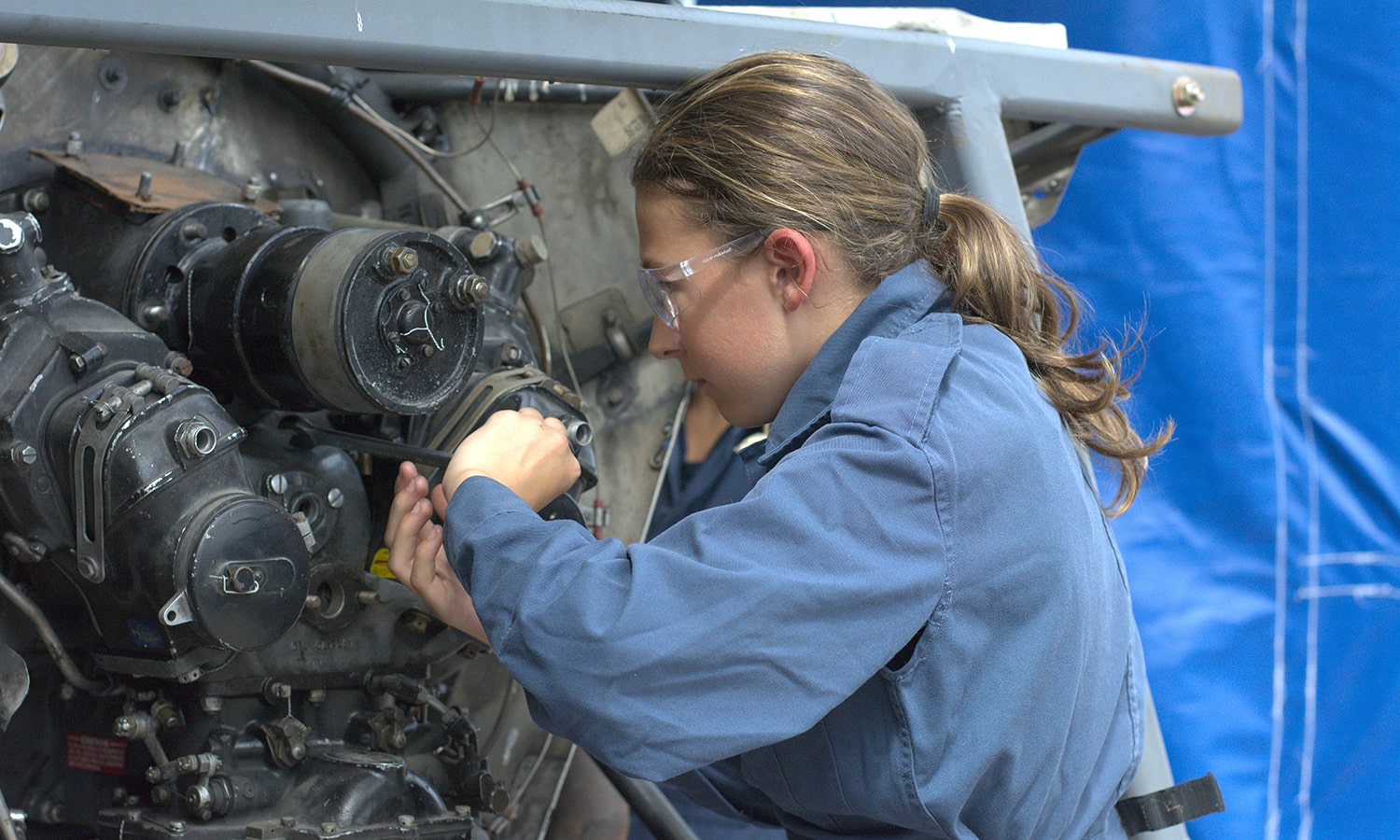 A cadet fixing an aircraft engine
