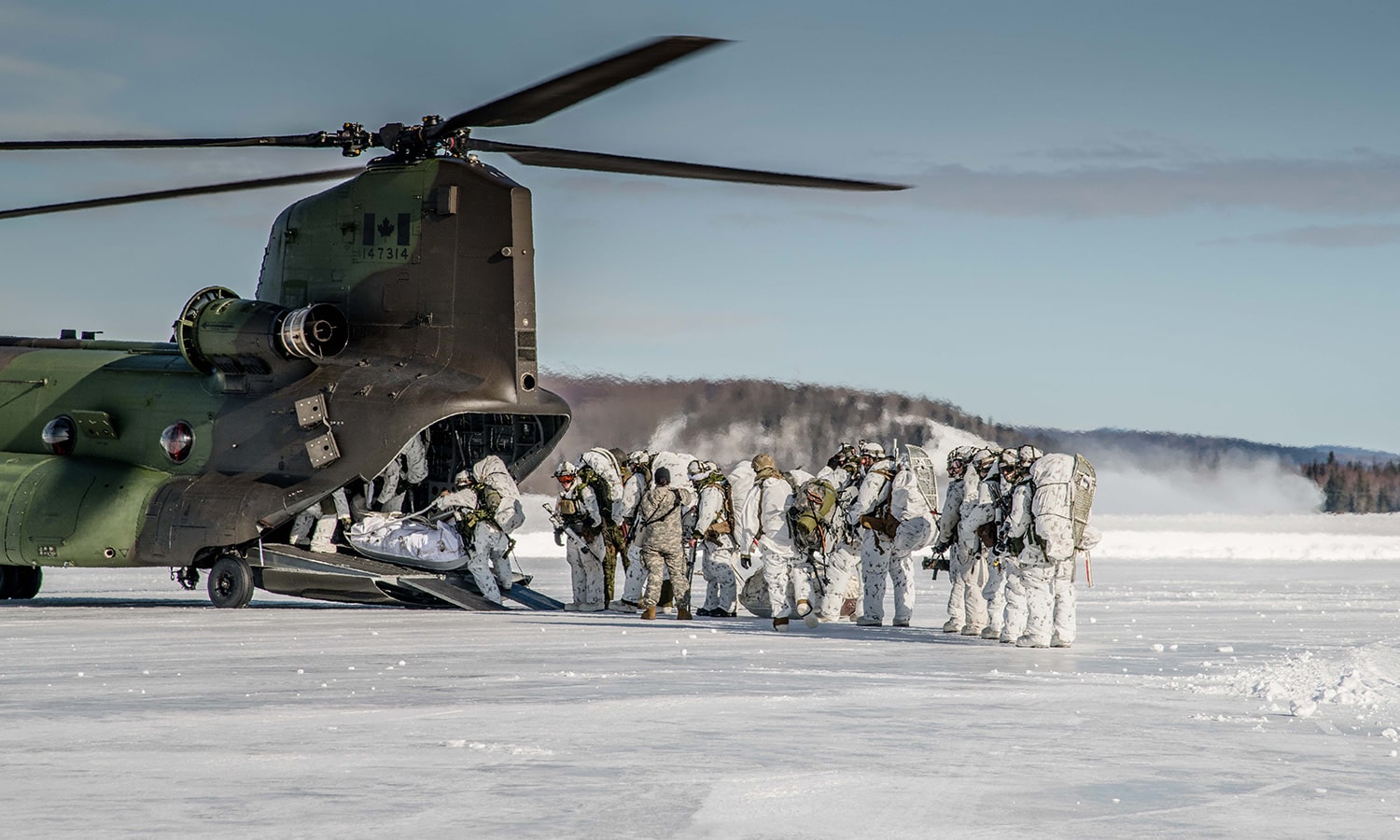 Members loading helicopter in snow